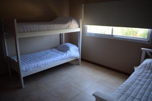 um quarto com 2 beliches e uma janela em Duplex Jacaranda II em Ciudad Evita