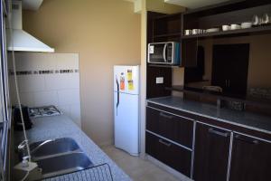 uma cozinha com um frigorífico branco e um micro-ondas em Duplex Jacaranda II em Ciudad Evita