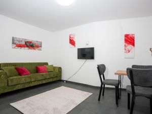 - un salon avec un canapé vert et une table dans l'établissement SR24 - Stillvolles gemütliches Apartment 4 in Recklinghausen, à Herten