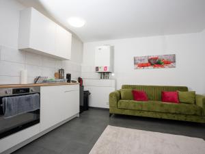 un salon avec un canapé vert dans une cuisine dans l'établissement SR24 - Stillvolles gemütliches Apartment 4 in Recklinghausen, à Herten