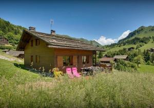 a house with pink chairs in front of it at Chalet Sicoria - Les Congères in Le Grand-Bornand