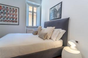um quarto com uma cama grande e almofadas brancas em Pgrhome Luxury Apartments Croce em Roma