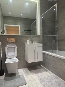 a bathroom with a toilet and a sink and a tub at Zs Apartments - St Albans City Centre - 20 mins from London in St. Albans