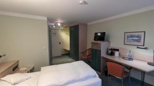 a hospital room with a bed and a desk and a computer at Hotel Gasthof Lang in Balingen