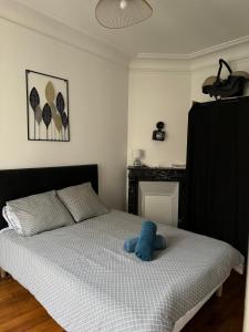 um quarto com uma cama com um bicho de peluche azul em Un appartement authentique à deux pas de Paris . em Saint-Mandé
