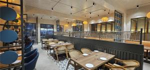 a dining room with wooden tables and chairs at Hotel Alwar Royals in Alwar