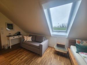 a living room with a couch and a window at Landgut Apfelrose in Friedrichshafen