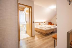 ein kleines Schlafzimmer mit einem Bett und einem Badezimmer in der Unterkunft Hotel - Gasthof Blume in Oppenau
