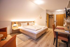 Hotel - Gasthof Blume في أوبناو: غرفة نوم بسرير كبير ومكتب