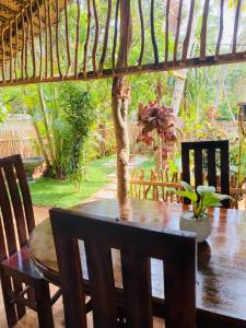 einen Esstisch mit Stühlen und einem Baum in der Unterkunft Art house hiriketiya in Dikwella