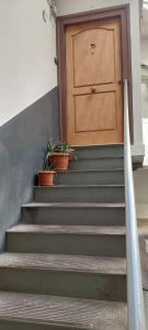 eine Treppe mit einer Tür und Topfpflanzen in der Unterkunft Dimora Filangieri in Neapel