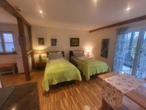 a bedroom with two beds with green comforters at Landgut Apfelrose in Friedrichshafen