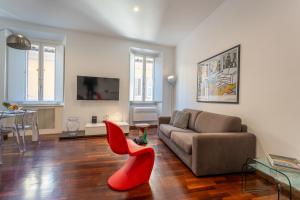 a living room with a couch and a red chair at PgrHome Croce in Rome