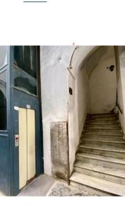 un escalier dans un bâtiment avec une porte bleue dans l'établissement Dimora Filangieri, à Naples