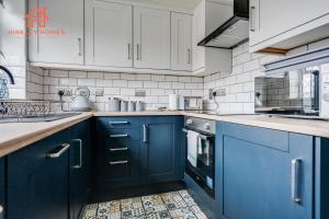 a kitchen with blue cabinets and white appliances at Spacious 2 bedroom-Birmingham/sleeps 8/freeparking in Birmingham