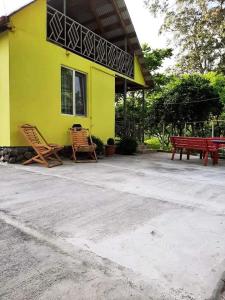 a yellow house with two chairs and a picnic table at Yellow chalet 021. in Batumi