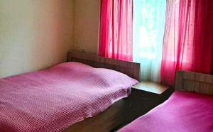 a bedroom with a pink bed and a window at Yellow chalet 021. in Batumi
