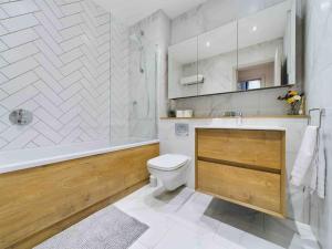 a bathroom with a tub and a toilet and a sink at stylish 2bed condo city centre in Manchester +20 photos
