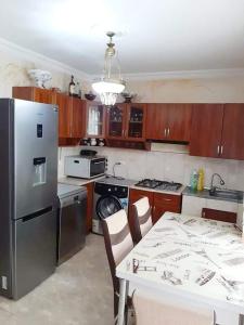 a kitchen with a refrigerator and a table with chairs at Yellow chalet 021. in Batumi