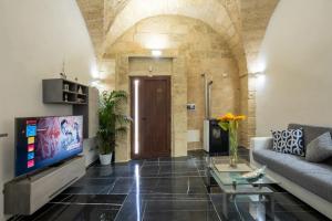 ein Wohnzimmer mit einem Sofa und einem TV in der Unterkunft Armonia Palace In Lecce With Panoramic View in Salice Salentino