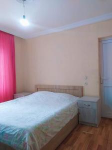 a bedroom with a bed and a pink curtain at Yellow chalet 021. in Batumi