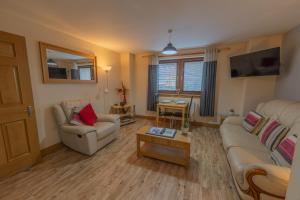 ein Wohnzimmer mit einem Sofa und einem Tisch in der Unterkunft Quay Head View Aparthotel in Stranraer