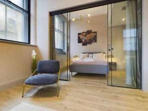 a bedroom with a bed and a blue chair at stylish 2bed condo city centre in Manchester