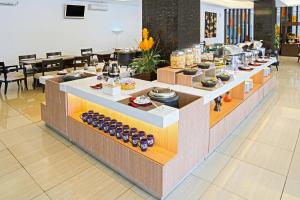a buffet line in a restaurant with food on display at FOX Hotel Gorontalo in Gorontalo