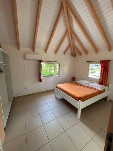 - une chambre avec un lit et 2 fenêtres dans l'établissement Logement Ghenoah, à Petit-Canal