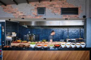 a person in a kitchen with a buffet of food at Glamour Hotel Istanbul Sirkeci in Istanbul