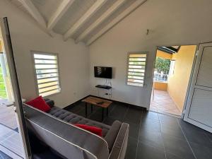 a living room with a couch and a television at Logement Ghenoah in Petit-Canal