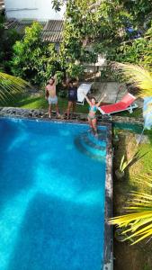 a group of people standing around a swimming pool at Tiny Royal Palace in Unawatuna