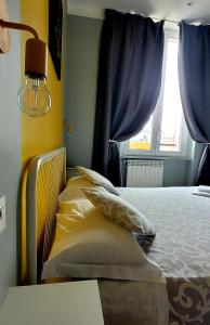 um quarto com uma cama com almofadas e uma janela em Al Binario Brescia em Brescia