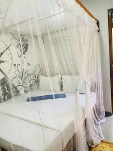 Bett in einem Zimmer mit Moskitonetz in der Unterkunft Art house hiriketiya in Dikwella