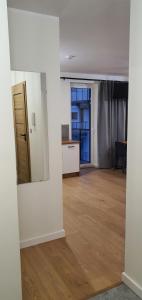 an empty room with a kitchen and a mirror at Oak Apartament Rumia Aquapark in Rumia