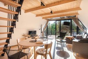 a kitchen and living room with a table and chairs at Budzi nas las 