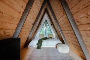 a cat sleeping on a bed in a tree house at Budzi nas las 