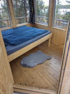 a bed in a wooden room with windows at Aurora Lodge in Jerfojaur