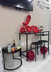 un tavolo con due sgabelli e un oggetto rosso sopra di Spazio Relax B&B 