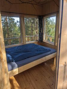 a bed in a room with two windows at Aurora Lodge in Jerfojaur