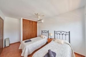 a bedroom with two beds and a ceiling fan at Ricardo in San José