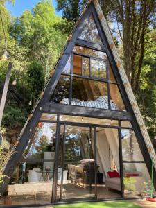 una casa de marco con paredes y ventanas de cristal en Alpina Liucura cabaña, en Pucón