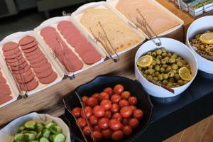 a table topped with different types of meats and vegetables at Glamour Hotel Istanbul Sirkeci in Istanbul