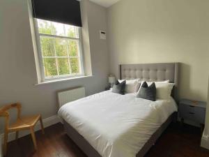 een slaapkamer met een groot wit bed en een raam bij Modern flat in Winchester