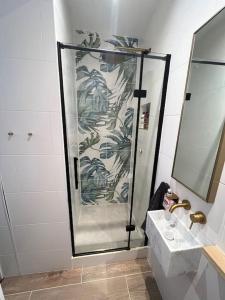 een douche in de badkamer met een wastafel en een spiegel bij Modern flat in Winchester
