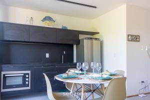- une cuisine avec une table et des verres à vin dans l'établissement Belo apto a 50m da praia de Tatuamanha TMHC104, à Tatuamunha