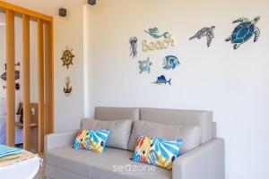 - un salon avec un canapé et des vignettes de tortues sur le mur dans l'établissement Belo apto a 50m da praia de Tatuamanha TMHC104, à Tatuamunha