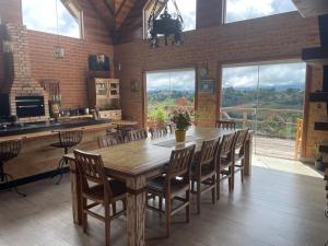 una grande sala da pranzo con un grande tavolo in legno e sedie di Bela Vista Chalé a Campos do Jordão