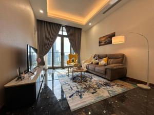 a living room with a couch and a television at Royce Residences by Romeo Bnb in Kuala Lumpur