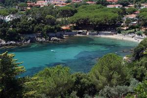 a beach with a body of water and trees at Attico cavo a pochi passi dal mare in Cavo +6 photos